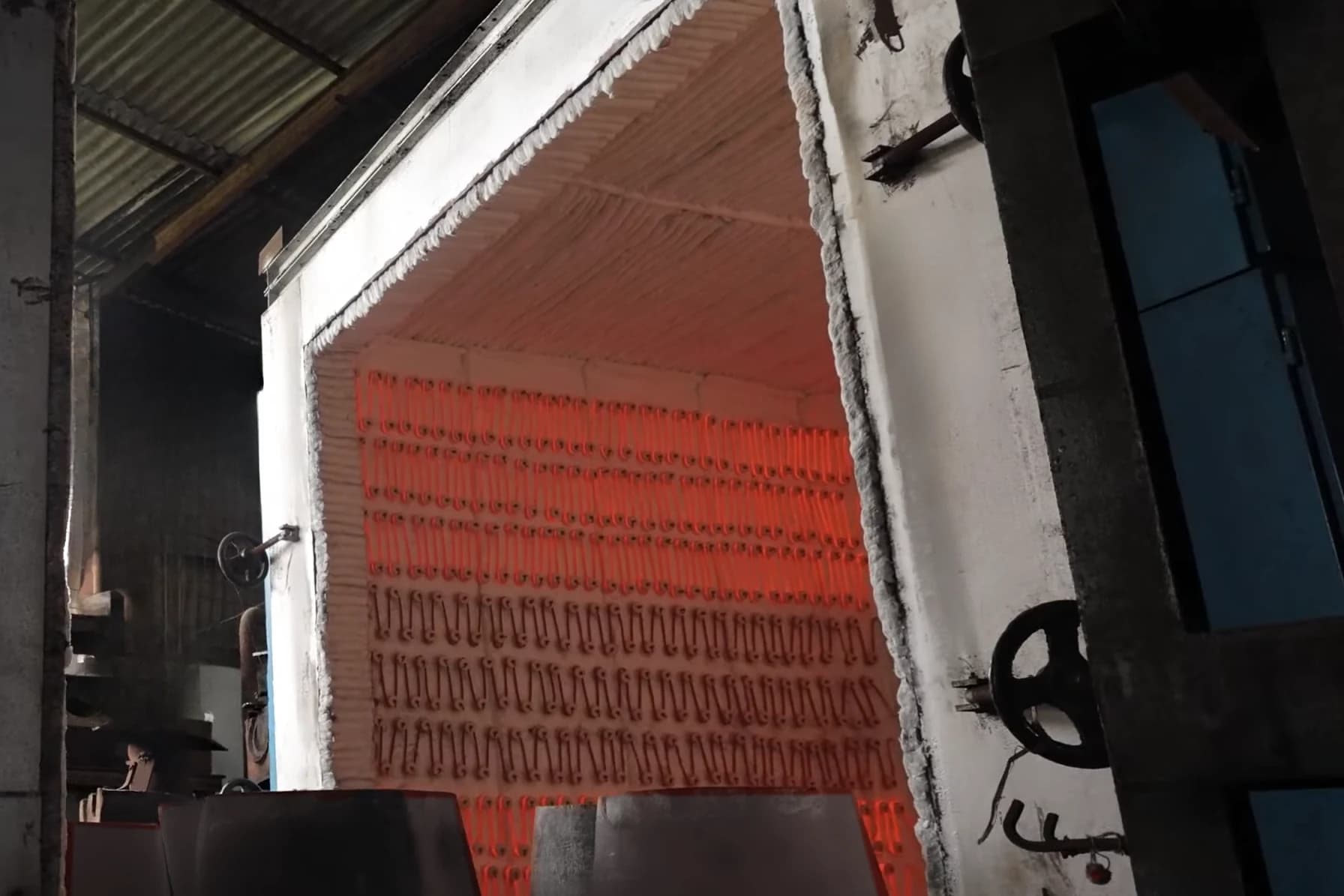 Electric heat-treatment furnace with its door open and the heating elements glowing