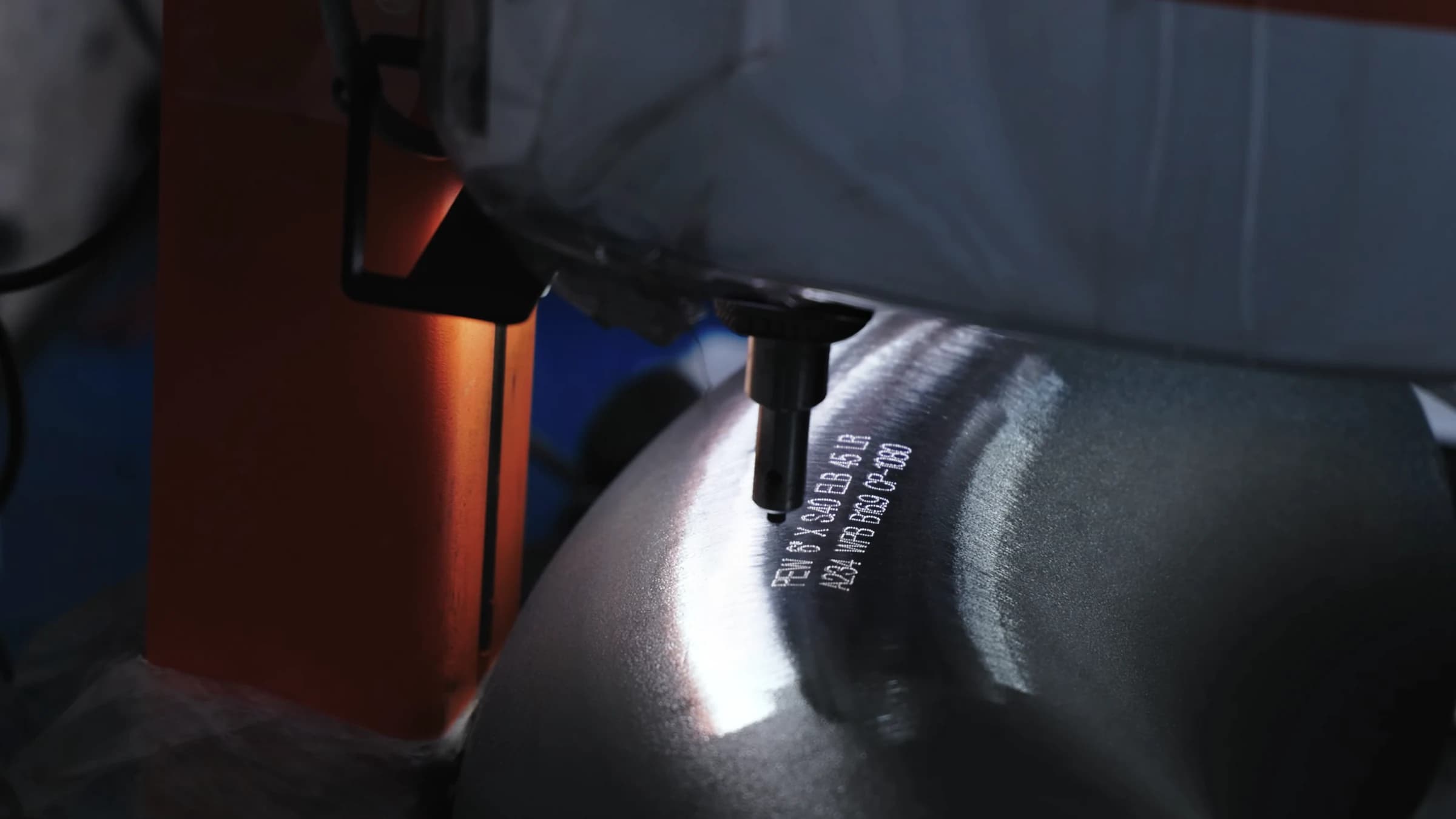 Dot-peen marking stylus over a carbon-steel 45° elbow and its fresh marking